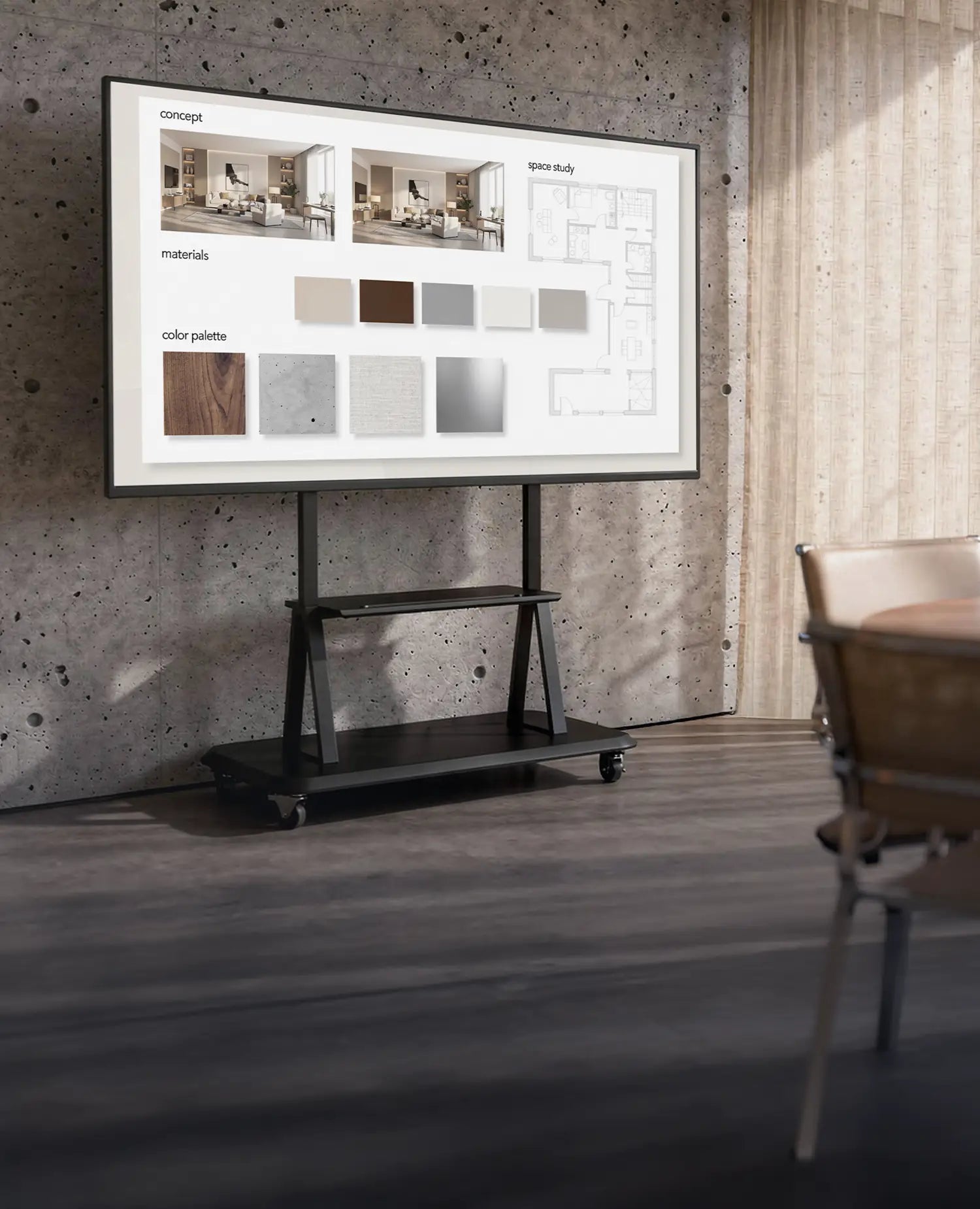 The image shows a modern meeting or creative workspace with a concrete wall and large windows with curtains. At the center stands a mobile presentation display on a celexon Professional height adjustable display trolley Adjust-55120MP, displaying a concept board with interior visualizations, material samples, and color palettes. The scene conveys a professional environment for architecture, design, or project meetings.